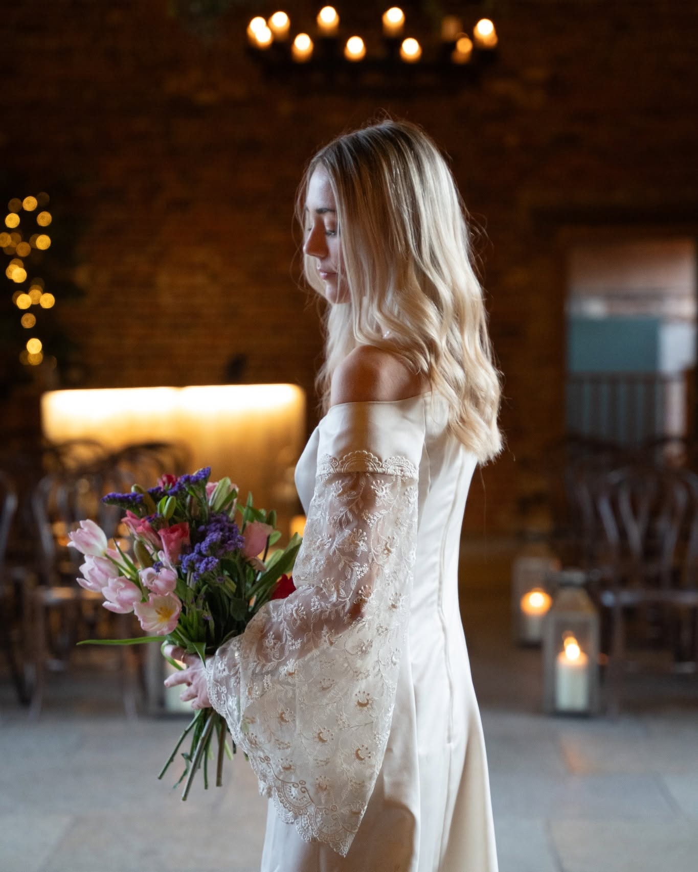 Bride in an off-shoulder lace gown holding her bouquet